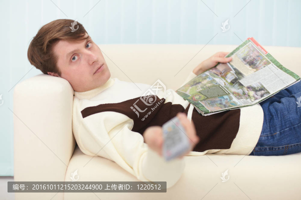 有報紙和遙控器的人