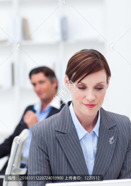 一個自信的女商人坐在辦公桌旁的肖像