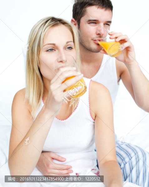 夫妻夫妻在床上喝橙汁