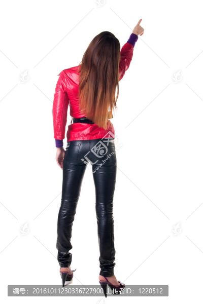年輕女子指著墻。后視圖。