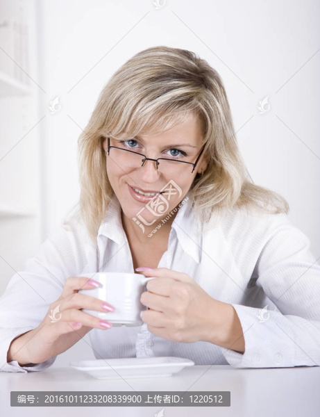 年輕的女人喝茶或咖啡