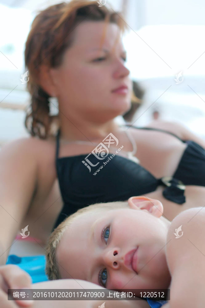 年輕的母親和她的兒子；在海邊的海灘上