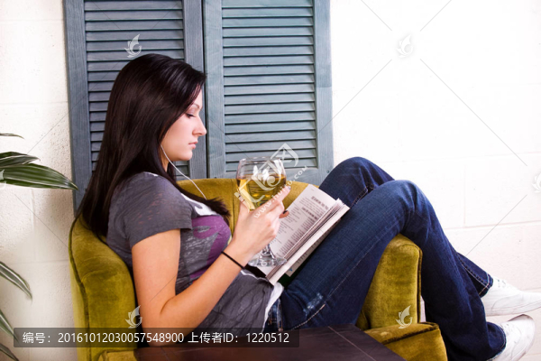 可愛的女孩在看書的時候喝酒