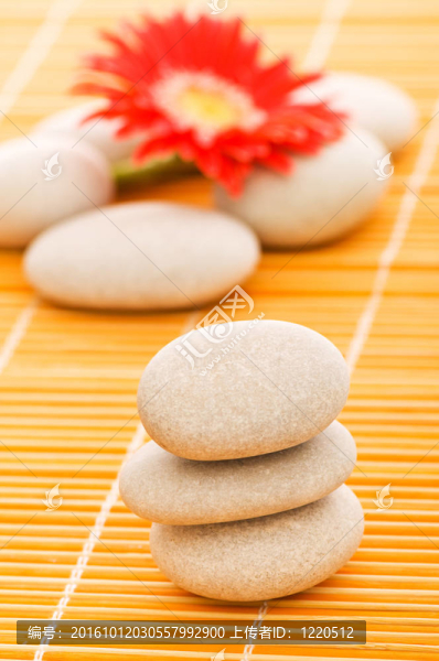 紅色花和堆棧的溫泉卵石