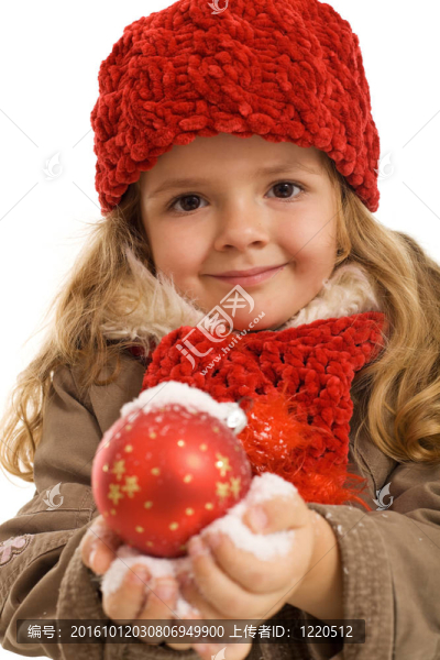 小女孩在雪地里抱著圣誕球