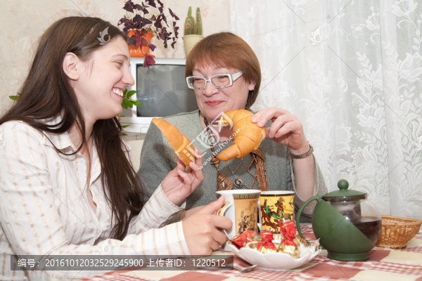 女孩和女人在廚房里喝茶