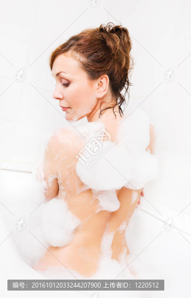 迷人的女人在浴缸里享受。