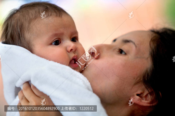 母親吻她的嬰兒