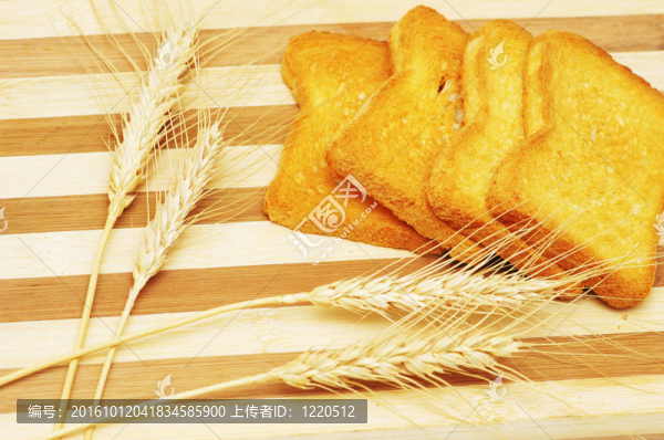 四塊面包片和小麥耳朵在木板上
