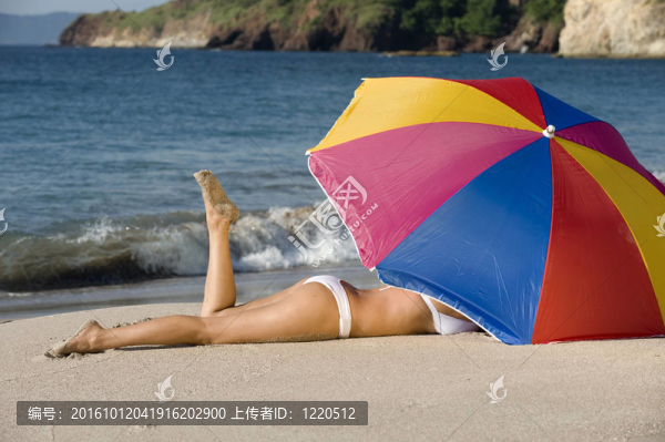 五顏六色的傘在熱帶海灘下白色比基尼漂亮的模型
