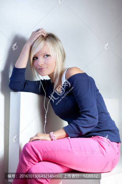 一個年輕漂亮的金發(fā)女人在她的MP3播放器聽音樂的肖像（做白日夢）