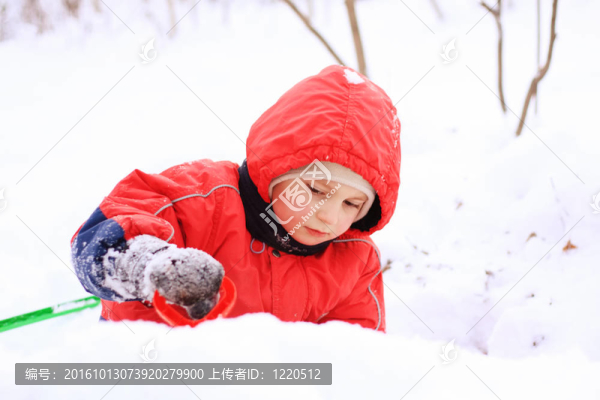 穿著紅色夾克的小孩在雪地里玩