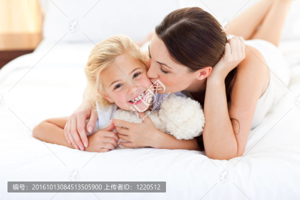迷人的母親親吻她的小女孩