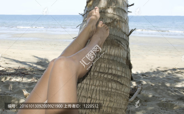在熱帶海灘上用腳休息的椰子腿