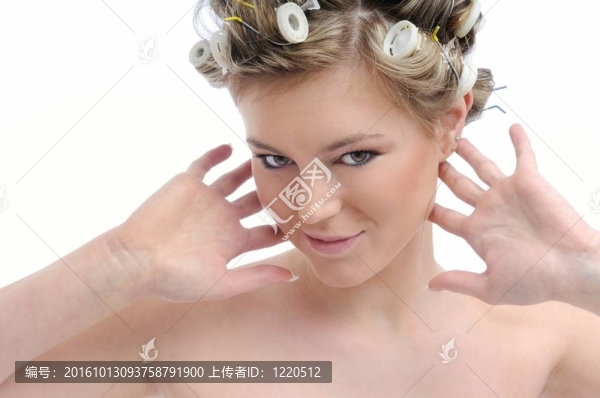 年輕漂亮的女人用卷發(fā)器假裝聽