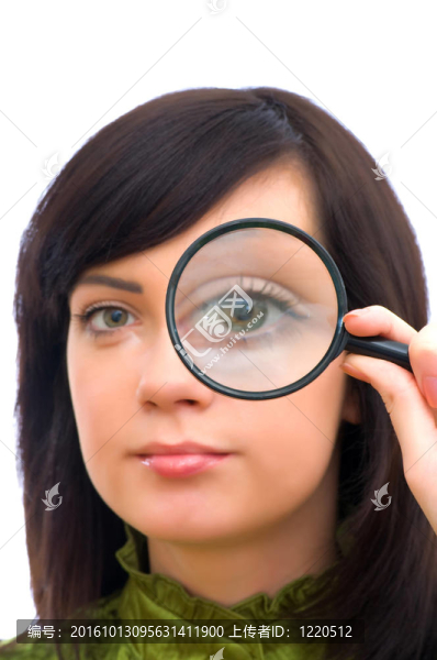 女孩的眼睛通過放大的玻璃放大