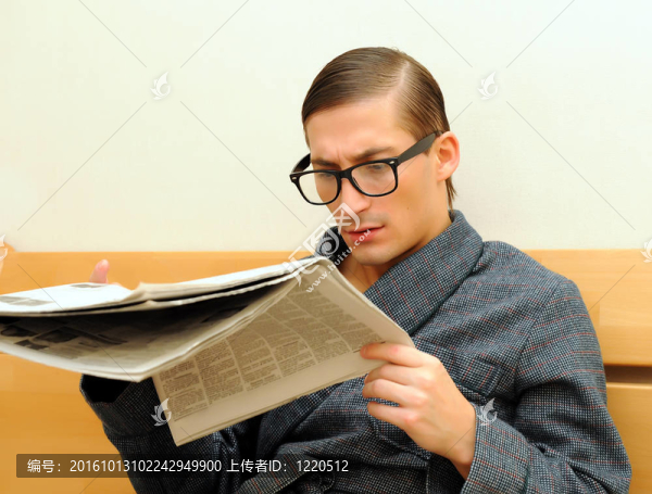 年輕英俊的男人在梳妝臺和眼鏡上看報紙