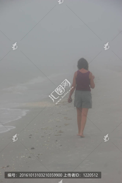 女人走霧蒙蒙的黎明海灘佛羅里達州薩尼貝爾