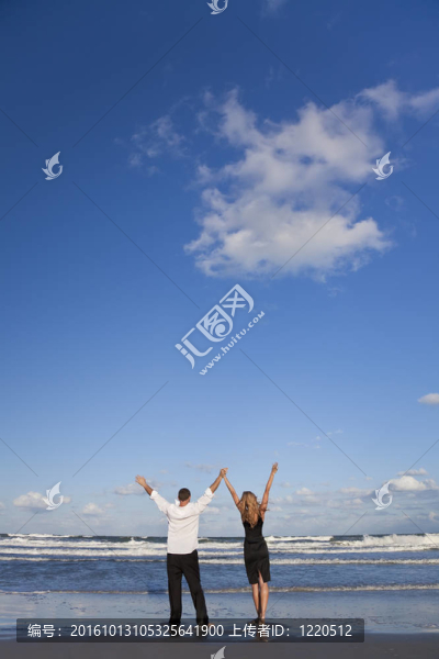 在海灘上慶祝武器的男女夫婦