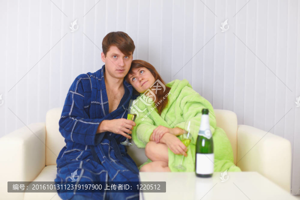丈夫和妻子坐在沙發(fā)上喝香檳