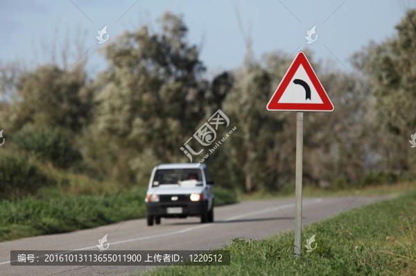 鄉(xiāng)間小路上有一條鋒利的曲線(xiàn)標(biāo)志和一輛小車(chē)