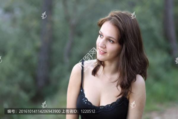 一個年輕漂亮的黑發(fā)女人戶外坐在墻上的一個小人物