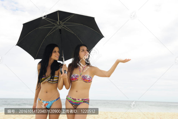 旅行者疾病保險(xiǎn)：兩個(gè)帶著雨傘的婦女在海灘上