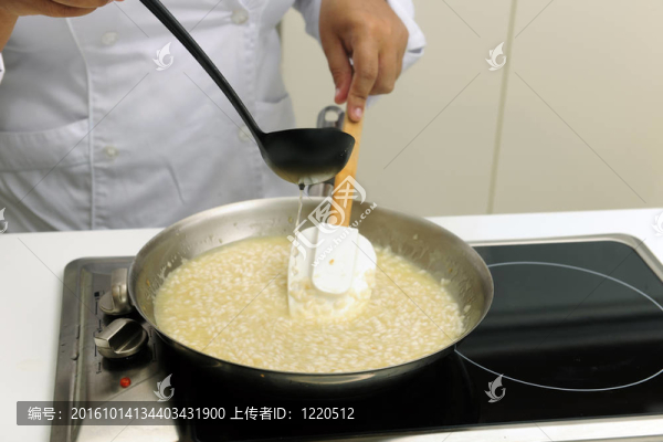 廚師烹飪燴飯加湯汁攪拌