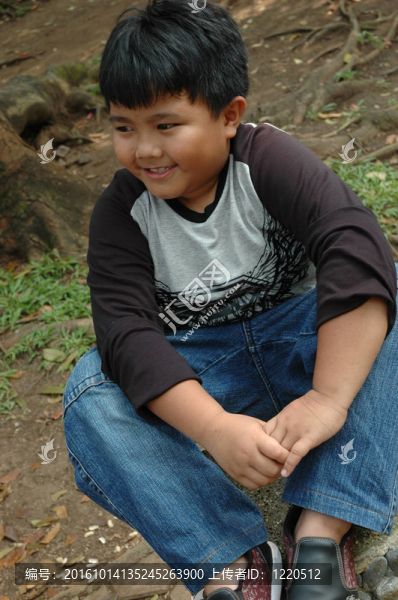 小男孩坐在公園里