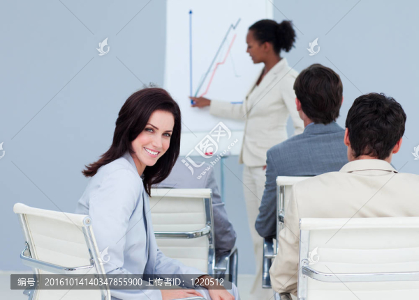 漂亮的女商人笑的相機在一個會議