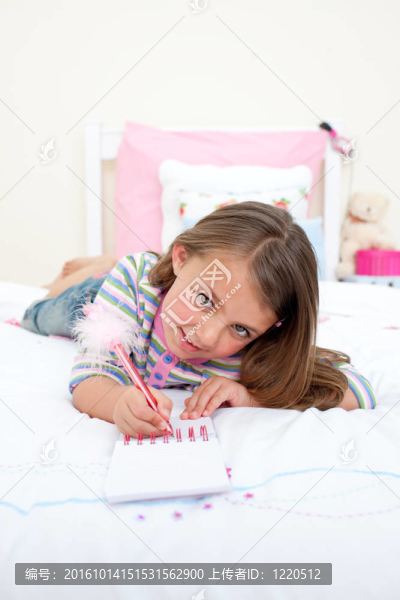 可愛的小女孩在筆記本上寫字