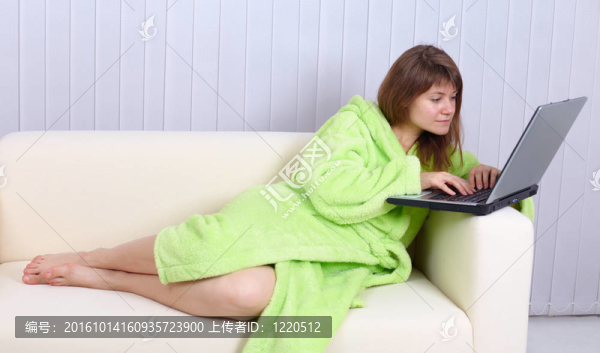 穿睡衣的年輕女人用筆記本讀郵件