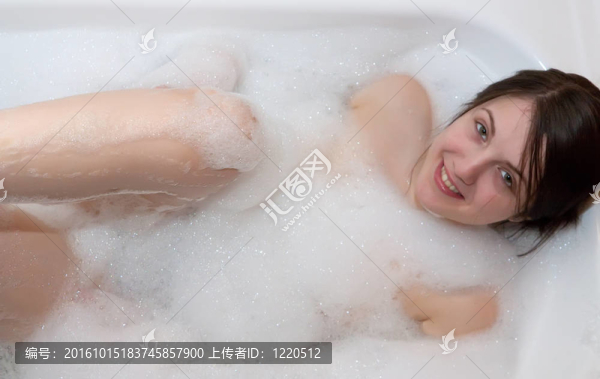 微笑的女人在浴缸里放松。