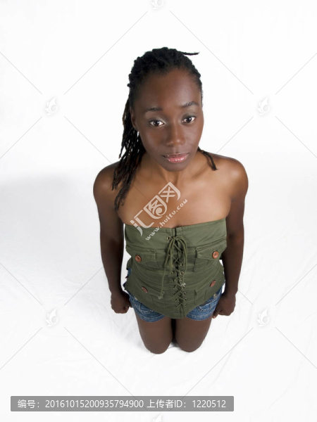 年輕的黑人女子跪在短褲和綠頂