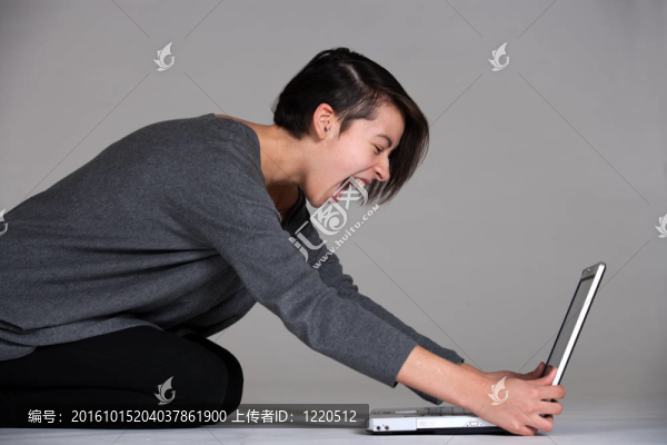 年輕女子在地板上用筆記本