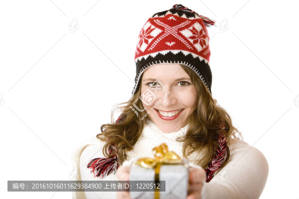 年輕的婦女在圣誕老人克勞斯的衣服舉行圣誕禮物在她的手中。白色隔離。
