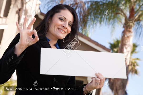 迷人的西班牙裔婦女在房子前舉行空白的跡象