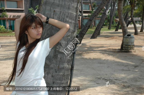 少女在椰子樹旁擺姿勢
