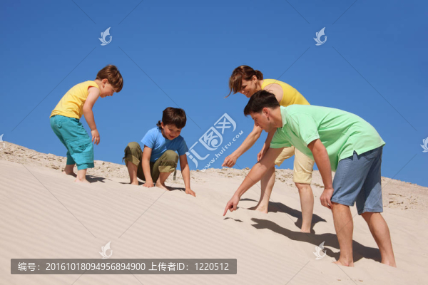 家庭在海灘上玩耍；發(fā)現(xiàn)某物