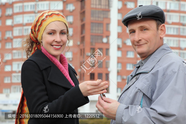 年輕女人微笑著給老年人對許多樓房鑰匙