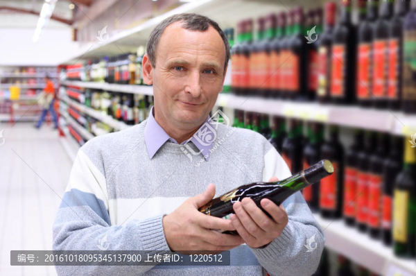 老人在商店里手里拿著酒瓶