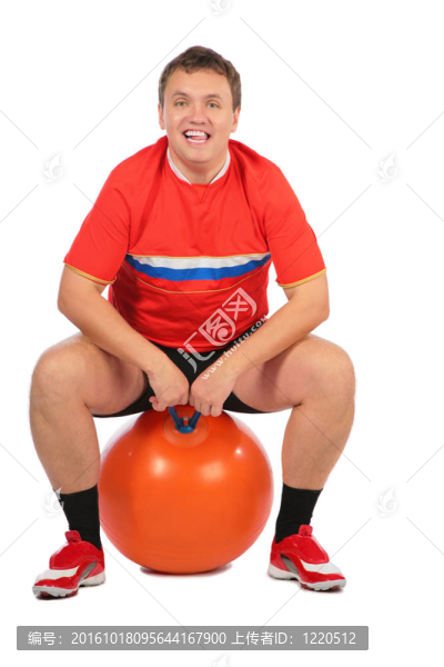 坐在健身球上的男人。