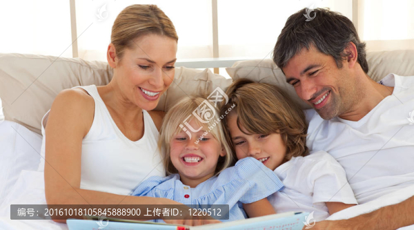 快樂的家庭在床上看書