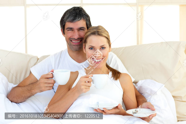 恩愛夫妻躺在床上喝咖啡