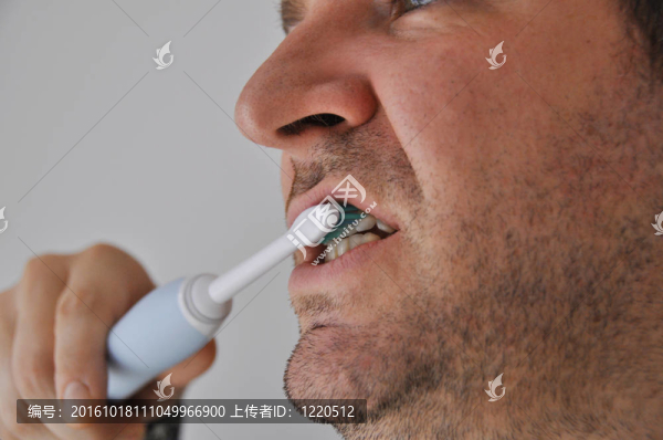男子用電動牙刷刷牙
