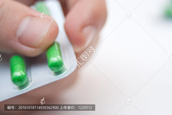 手拿綠色膠囊