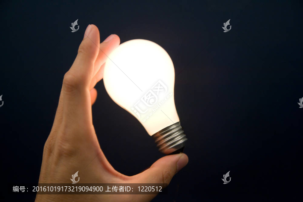 手拿著一個明亮的燈泡