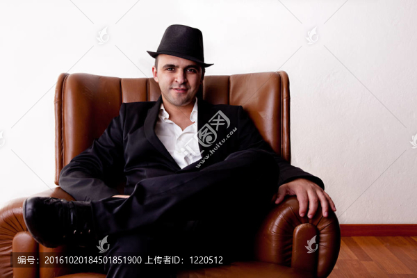 坐在椅子上的帽子的男人