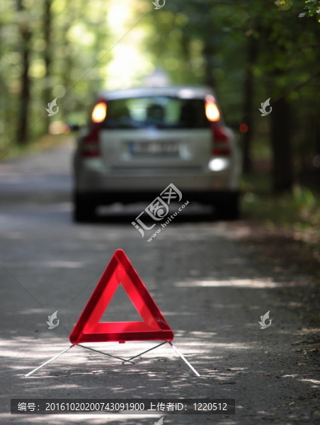 拋錨的車，后面有警告三角，等待救援到達（淺景深；焦點在三角形上；汽車沒有焦距）