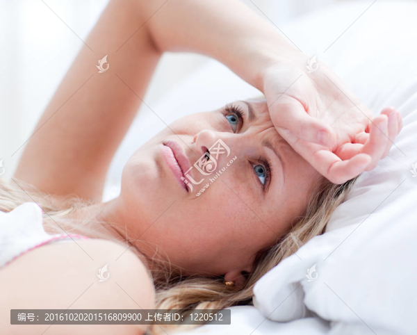 有偏頭痛的婦女躺在床上